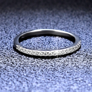 Moissanite 925 silver ring featuring a single row of sparkling pavé set stones on blue background