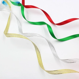 Close-up of four colors of decorative Christmas ribbons in satin and metallic textures