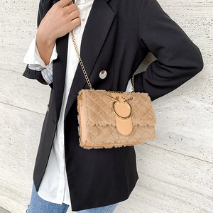 Close-up of beige plush crossbody bag with gold chain and metal deer head closure