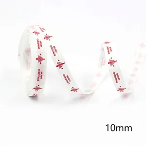 Close-up of 10mm white Christmas ribbon with red trees and Merry Christmas text