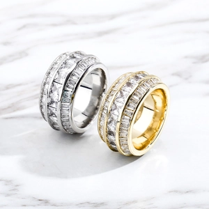 Macro detail of gold and silver hip hop rings with triple-row baguette cubic zirconia