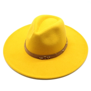 Detail of a bright yellow wool fedora featuring a multilayered brown cord band and gold beads