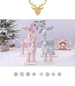 Gros plan de rennes de Noël en tissu rose et gris avec étoiles et socles en bois