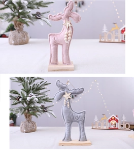 Détail de rennes de Noël mignons en peluche avec étoiles en bois sur décor de fête