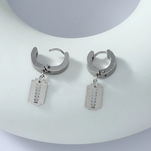 Detail of silver stainless steel razor blade pendant on a sleek metal hoop earring