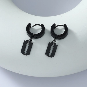 Detail shot of black stainless steel razor blade pendant earrings on a white display