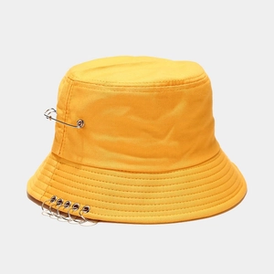 Vue détaillée du chapeau bob jaune avec cinq anneaux en métal et une épingle