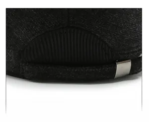 Close-up of adjustable metal buckle and textured wool fabric on a men's winter flat cap