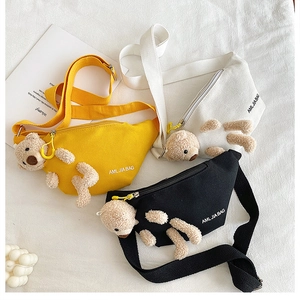 Detailed flat lay of canvas crossbody bags in yellow, white, and black with cute plush bears
