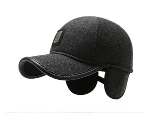 Detail view of winter baseball cap with dark grey wool texture and leather brim edge