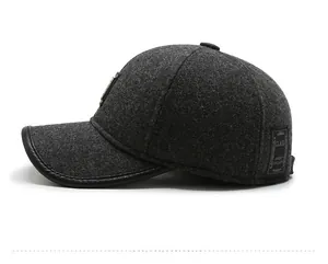 Detail of dark grey wool baseball cap with side metal logo and leather brim trim