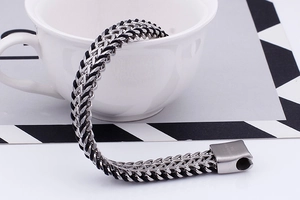 Detail of 316L stainless steel magnetic clasp on a black braided men's bracelet
