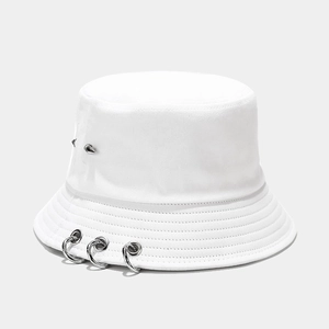 Détail d'un chapeau bob blanc en toile avec anneaux métalliques et rivets argentés