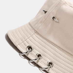Détails de chapeau bob beige avec anneaux en métal et rivets pointus argentés