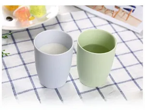Set of two minimalist light blue and green travel cups on a checkered tablecloth