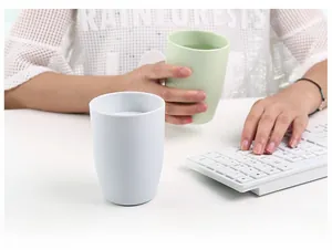 Minimalist portable travel cups in white and light green shown in an office setting