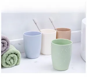 Close-up of four Morandi colored matte plastic tooth cups with water droplets