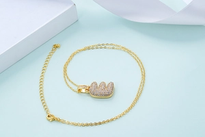 Vue macro du pendentif lettre E plaqué or avec zircons et fine chaîne dorée