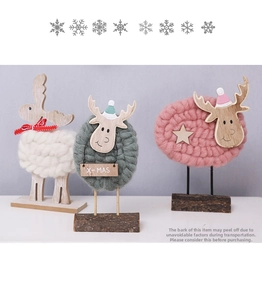 Close-up of handmade wool felt Christmas reindeer ornaments with wooden base and X-MAS tags