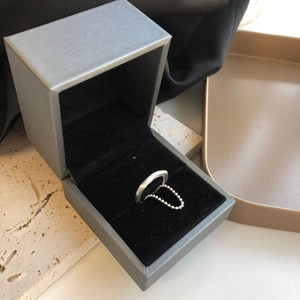 Silver bead chain ring presented on a gray jewelry box with a professional still life setting