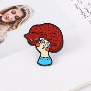 Broche en émail artistique avec chat rouge et visage de femme sur un magazine