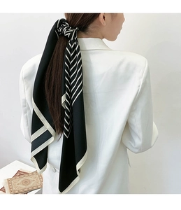 Classic black and white striped silk scarf tied as an elegant hair accessory on model