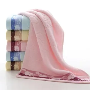 Close-up of thick cotton towels with cartoon sheep patterns and wave jacquard edges