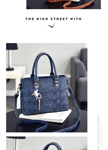 Close-up of blue textured leather handbag with woven details and tassel charm