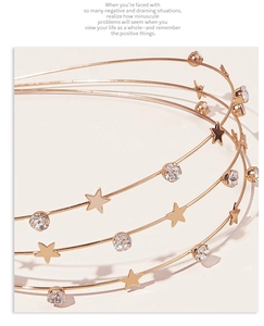 Detailed close-up of a three-layer gold headband with sparkling stars and rhinestones