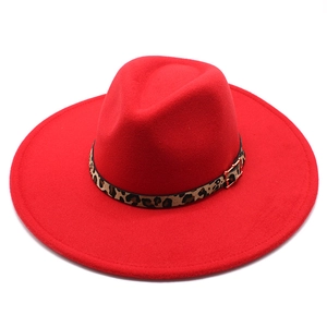 Detail of red fedora hat with leopard print leather band and golden metal buckle