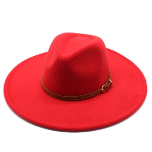 Detail view of red wide brim fedora hat with brown faux leather belt and gold buckle