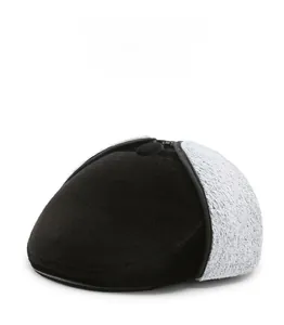 Detail of warm winter flat cap featuring thick fleece ear flaps and soft black suede material