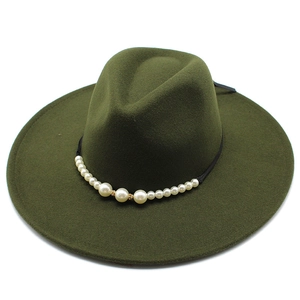 Detail of dark green wide brim fedora hat featuring white pearls and gold rhinestone accents