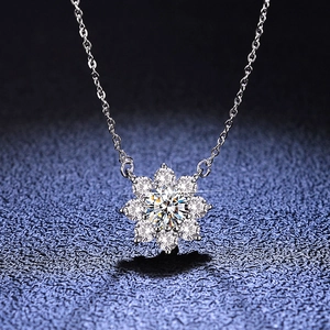 Macro shot of sparkling sunflower moissanite pendant with 925 silver chain on blue background