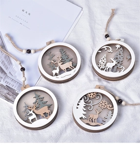 Detail of wooden Christmas ornaments featuring laser-cut elk and forest scenery