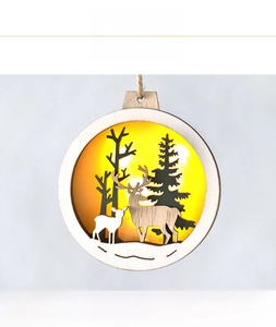 Detail of wooden Christmas ornament with glowing LED light and hollow reindeer forest scene