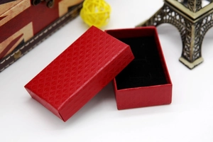 Macro detail of red diamond-textured paper jewelry gift box with black velvet lining
