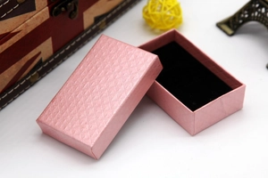 Detail of pink rectangular jewelry box with diamond texture and black velvet lining