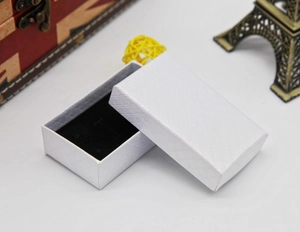 Detailed view of white textured jewelry box with black velvet lining for rings