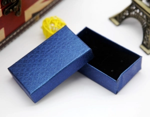 Detail of navy blue diamond pattern jewelry box with black sponge lining and textured finish