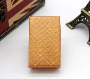 Close-up of golden rectangular jewelry box with detailed diamond pattern texture