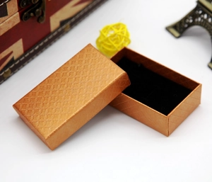 Macro shot of gold jewelry box with diamond texture and black velvet lining insert