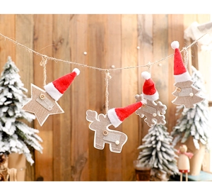 Christmas ornaments with elk, stars and snowflakes hanging on a rustic hemp rope