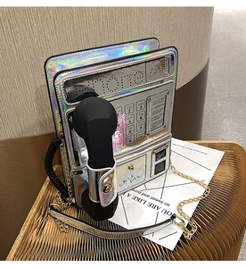 Close-up of retro phone shaped crossbody bag with iridescent laser finish and chain strap