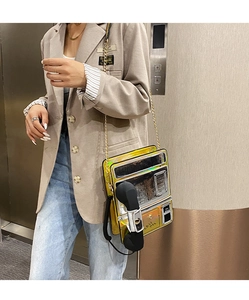 Détail du sac à bandoulière en forme de téléphone rétro doré avec chaîne et texte Call Me