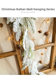 Snow-flocked Christmas garland with pine cones and LED warm lights on wood