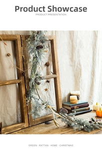 Detail of snow-flocked Christmas garland with pine cones and white berries on wooden background