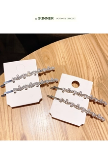 Macro detail of wavy rhinestone hair pins with pearls on gold and silver metal bases