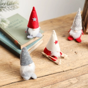 Set of four knitted Christmas gnomes with ski accessories on a cozy wooden table decor