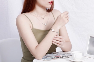 Silver double-layer cross necklace and matching bracelet set worn by a female model